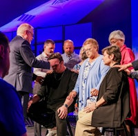 a group of people standing around a man in a suit