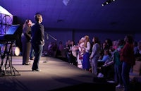 a group of people standing on a stage in front of a microphone