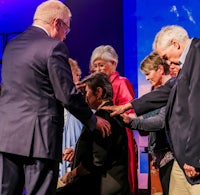 a man in a suit is being baptized by a woman