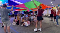 a group of people holding up a colorful kite